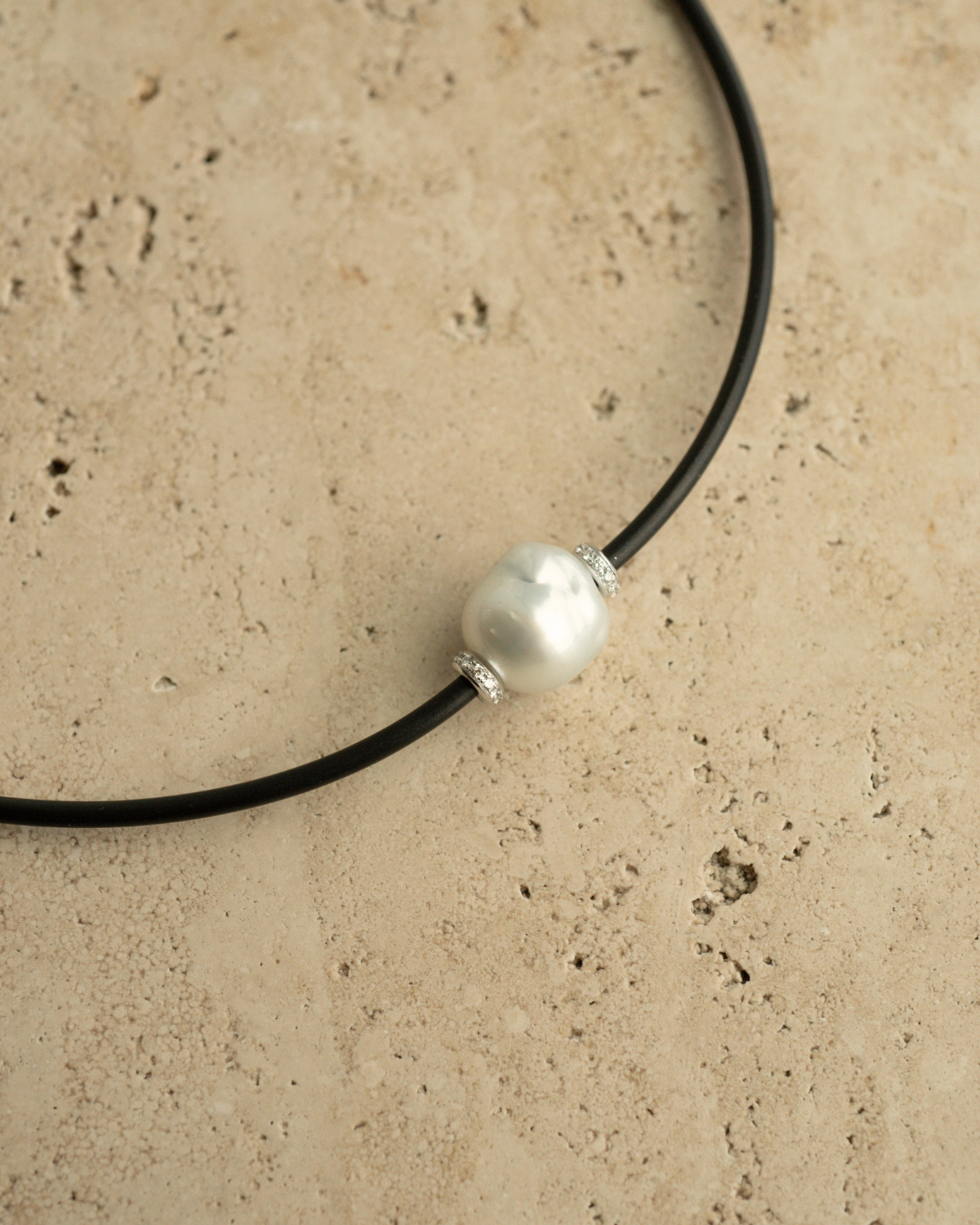 A gorgeous Baroque Australian South Sea pearl set alongside two white diamond rondels on a neoprene necklace.