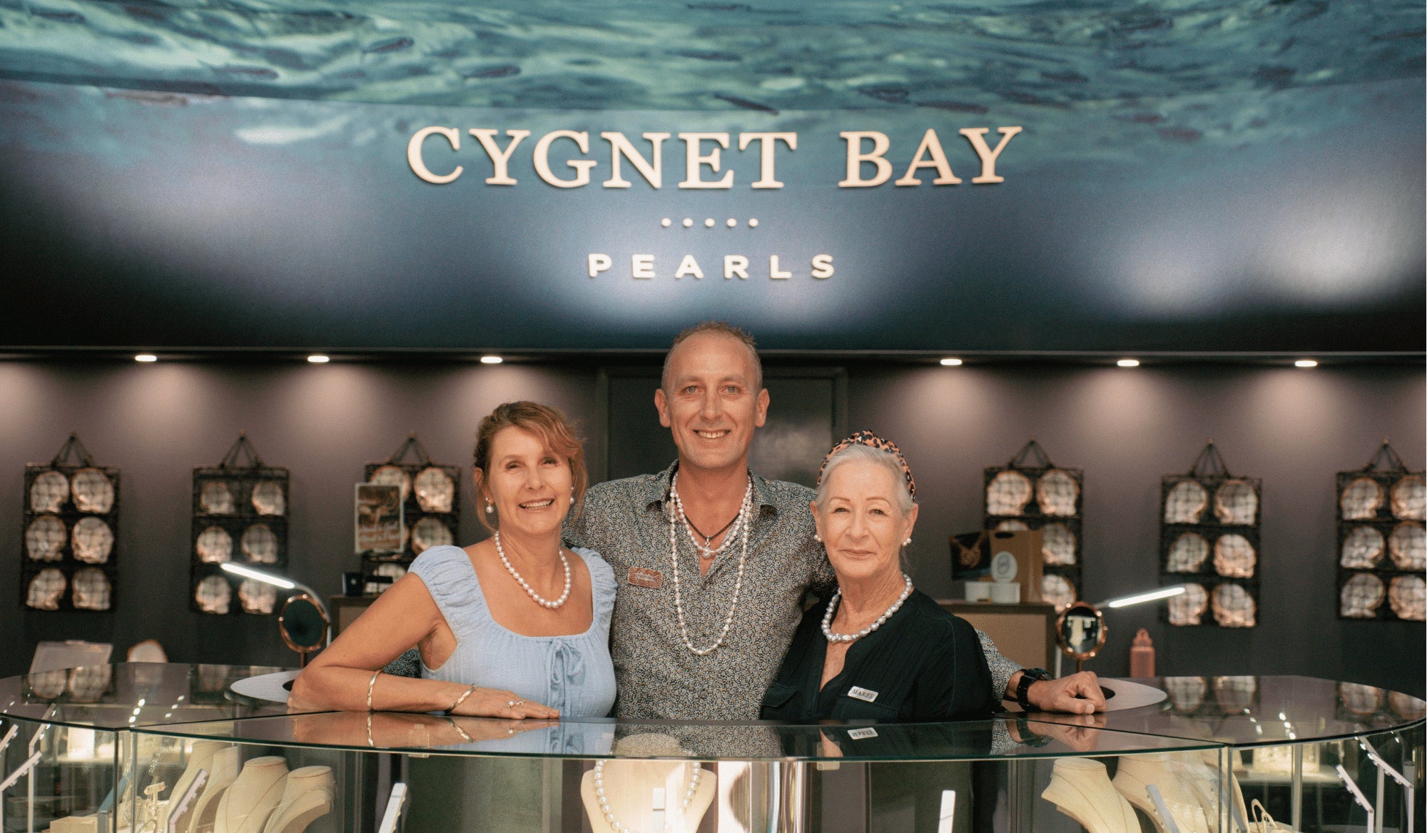 The Broome Showroom team stand behind their cabinetry, smiling at the camera, ready to welcome any customers to the showroom.