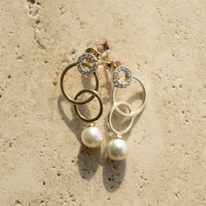 A pair of stunning pearl earrings featuring rings of gold in varying sizes.