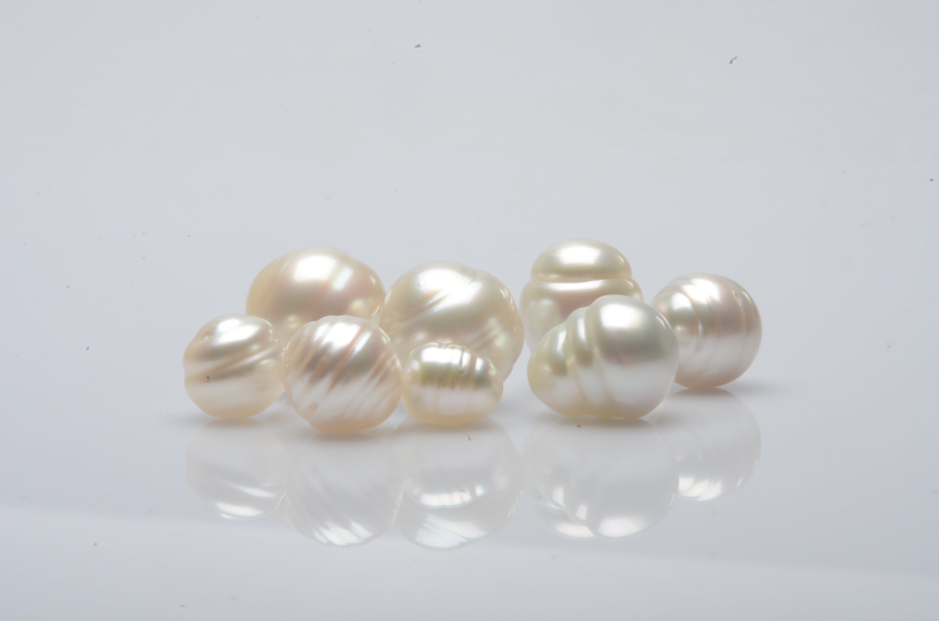 A group of circle pearls of different sizes, all shining in their natural colour and lustre.