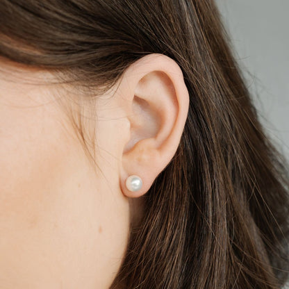 A woman wears her stunning classic akoya pearl studs.