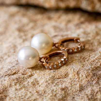 A pair of Australian South Sea pearls set in gold, with a design incorporating sparkling white diamonds.