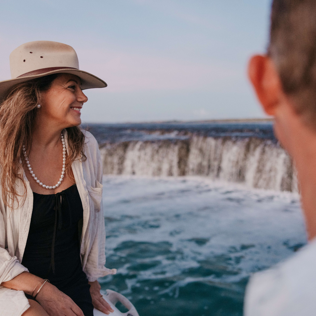 A guest smiles broadly as the looks at our Waterfall Reef during a Sea Safari tour. She wears her stunning Pearls of Australia pearl strand necklace and matching pearl stud earrings. 