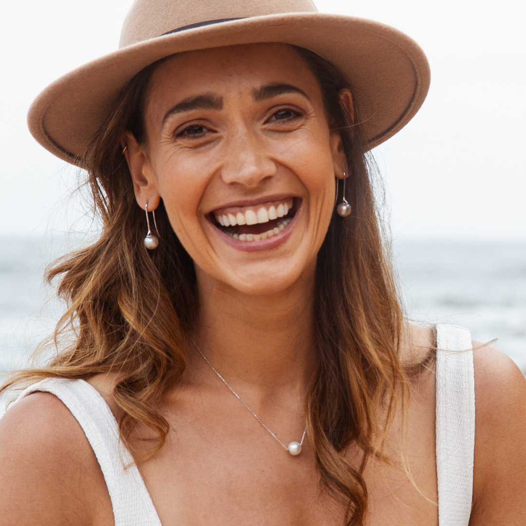 A woman wears her stunning Australian South Sea pearl set on a gold chain necklace.