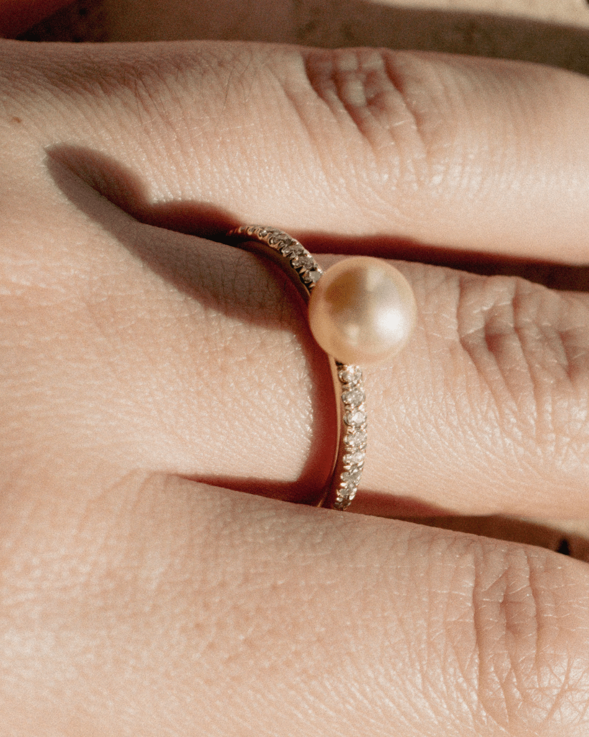 A stunning Eternal Diamond Pearl Ring featuring our Broken Bay grown Australian Akoya pearl set alongside a row of white glimmering diamonds on a gold band. 