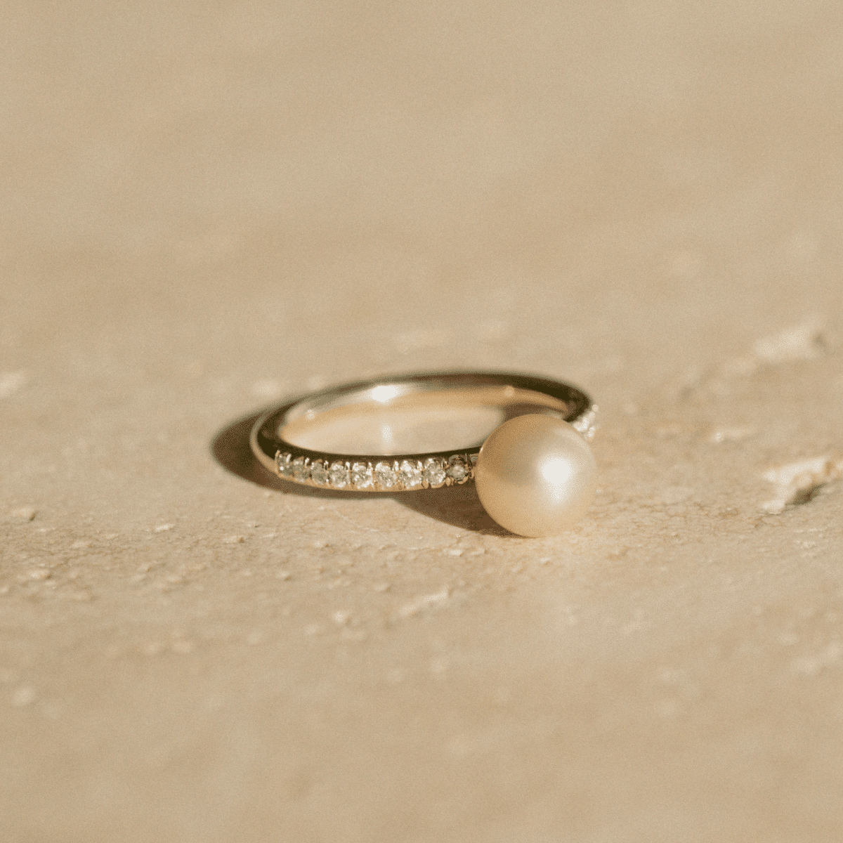 A stunning Eternal Diamond Pearl Ring featuring our Broken Bay grown Australian Akoya pearl set alongside a row of white glimmering diamonds on a gold band. 