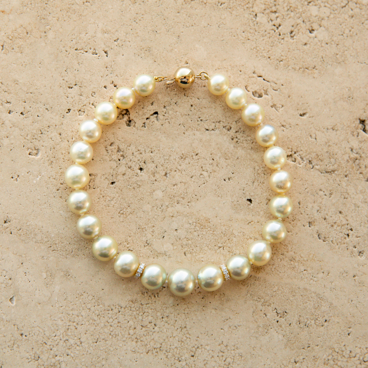Pearl strand bracelet on a beige stone surface