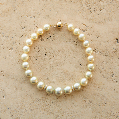 Pearl strand bracelet on a beige stone surface