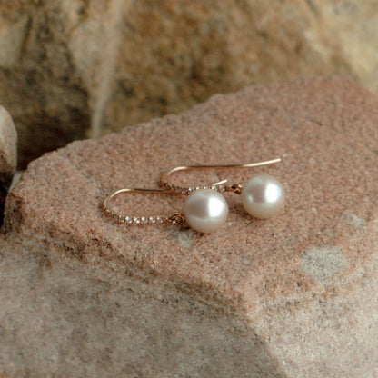 A pair of stunning Australian Akoya pearls set on a pair of hook earrings, alongside a row of sparkling white diamonds.