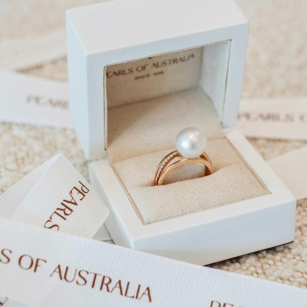 This Eternal Pearl Ring features a Cygnet Bay (WA) grown 11mm Round A2+ grade Australian South Sea pearl set on a band with a row of 18 White Diamonds. It is photographed in its iconic Pearls of Australia luxury packaging.