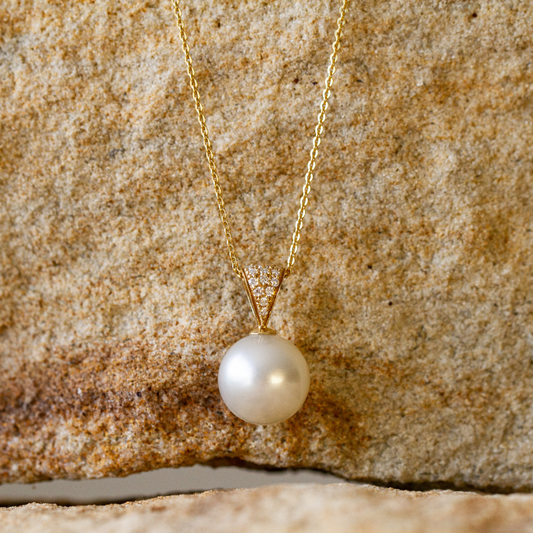 A magnificent pearl pendant featuring an Australian South Sea pearl set alongside a myriad of white diamonds in gold.