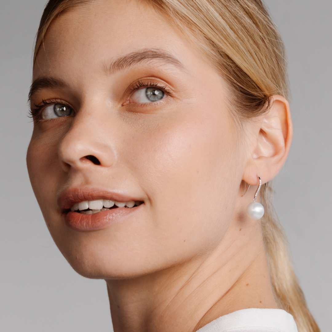 A woman wears her beautiful Eternal Hook Earrings featuring Cygnet Bay grown Australian South Sea pearls set in gold. 