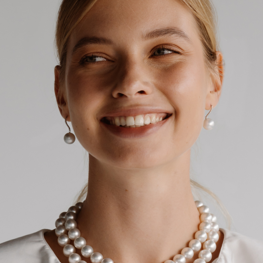 A woman wears her beautiful Eternal Hook Earrings featuring Cygnet Bay grown Australian South Sea pearls set in gold. 