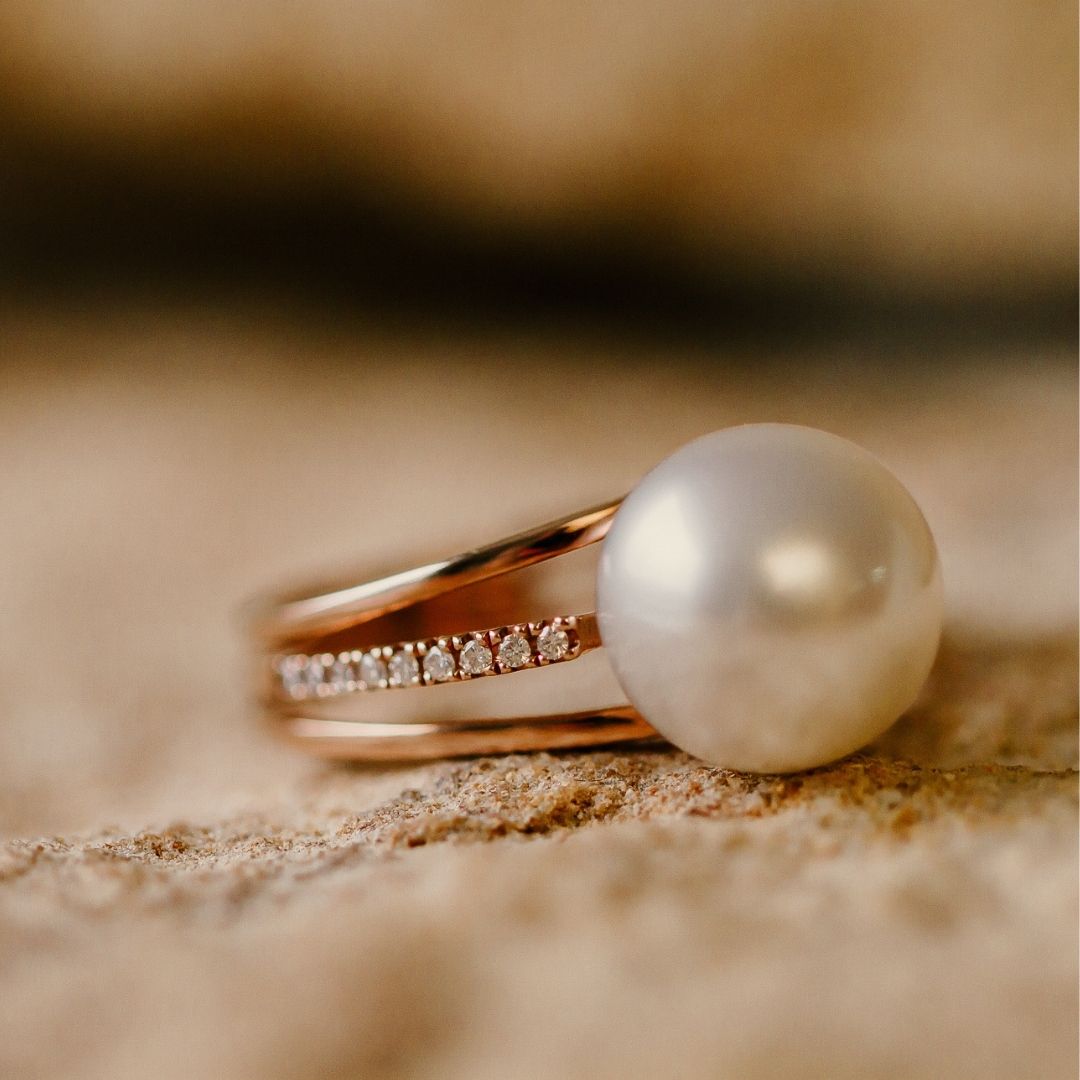 A striking pearl ring, featuring an Australian South Sea pearl set alongside a band of white glimmering diamonds. 