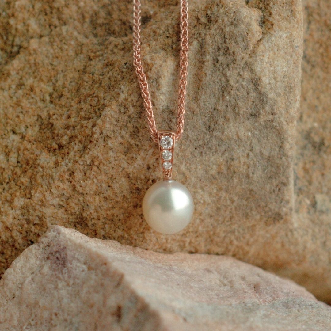 A gorgeous Australian Akoya pearl pendant set in gold, with a row of three white diamonds glimmering alongside the natural colour and lustre of our Australian grown pearl.