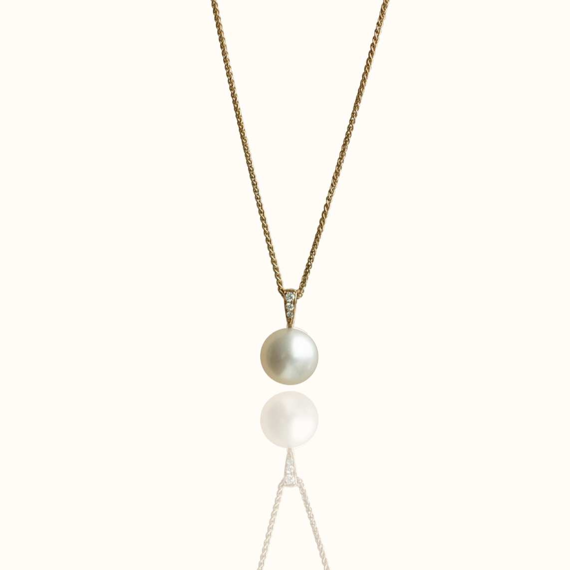 A stunning Australian South Sea pearl set on a yellow gold pendant, with three white diamonds on the bail of the design.