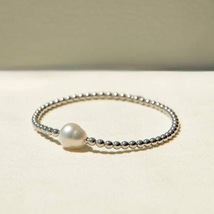 Pearl bracelet with silver beads on a beige background