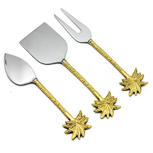 Set of four silver and gold leaf-themed utensils on a white background