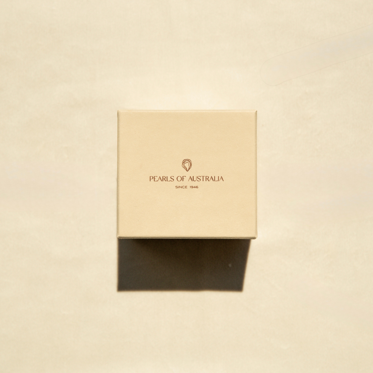 Beige box with 'Pearls of Australia' logo on a beige background