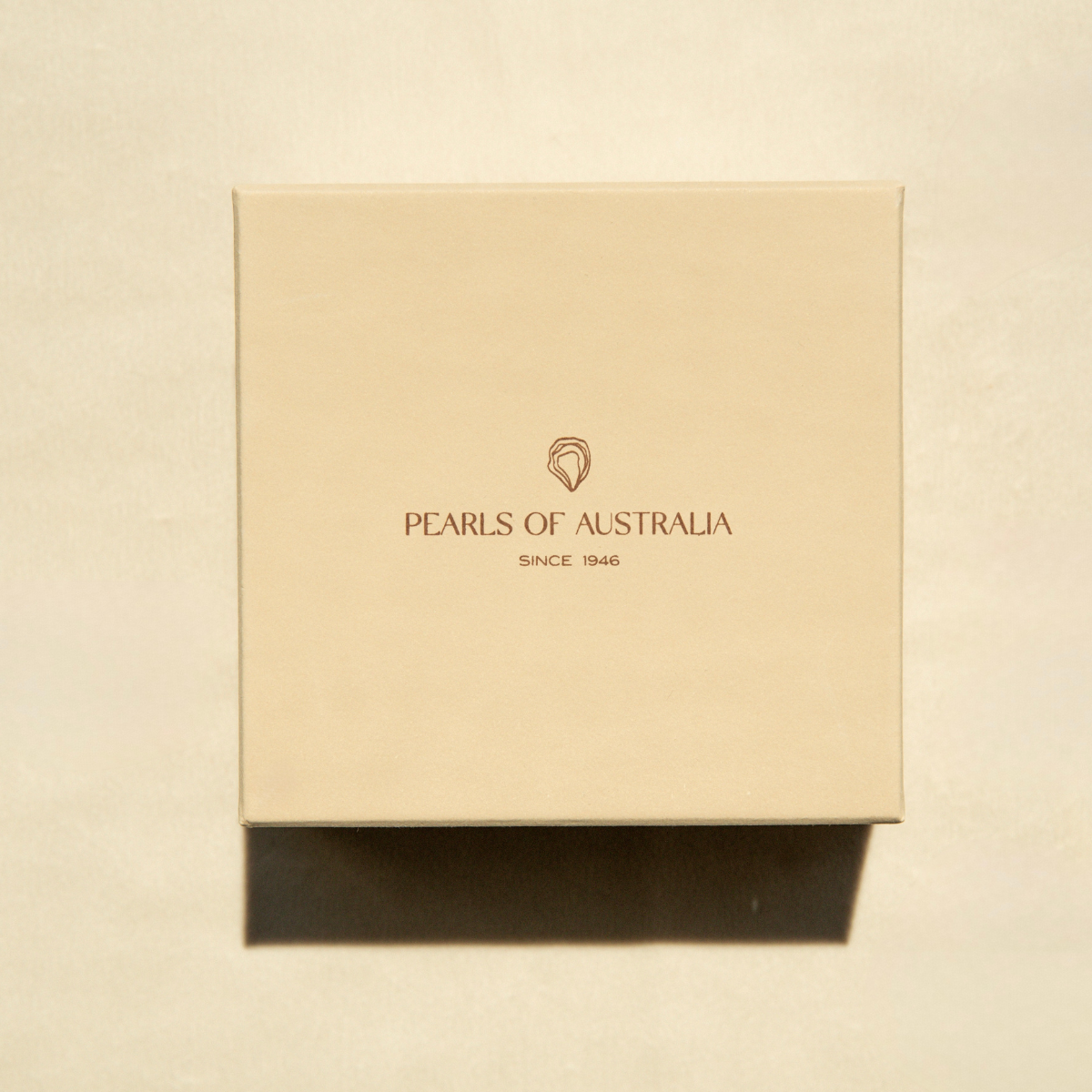 Beige box with 'Pearls of Australia' logo on a beige background
