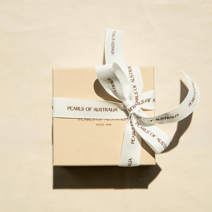 Pearls of Australia gift box with a ribbon on a beige background