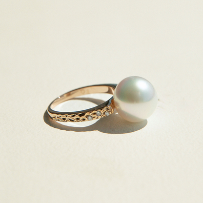 Gold ring with a pearl on a beige background