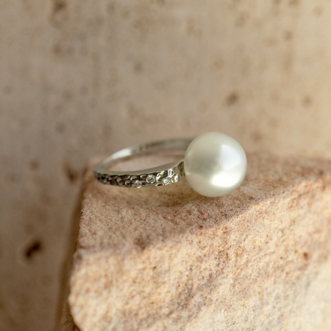 This beautiful 18ct white gold hammered ring from the Impressions collection features a beautiful 10.5mm High Button A1 grade Cygnet Bay (WA) grown South Sea Pearl complimented by 6 White Diamonds (0.06 H/SI) in a size #M.