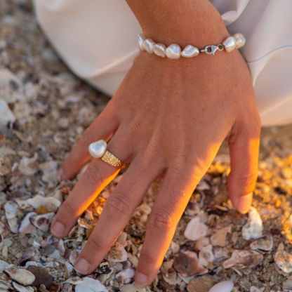 A woman wears her beautiful Impressions Pearl Keshi Ring set in a hammered gold design.