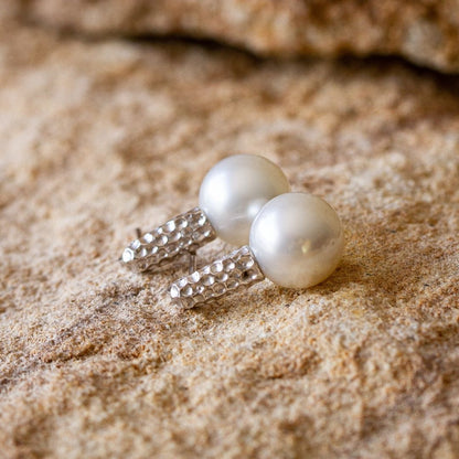 A pair of stunning Australian South Sea pearls set in a hammered gold design.