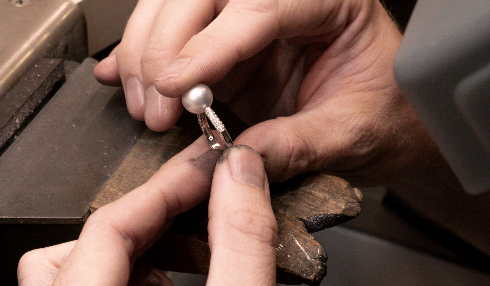 Close-up of hands working on a pearl ring at our Perth Studio in Subiaco.