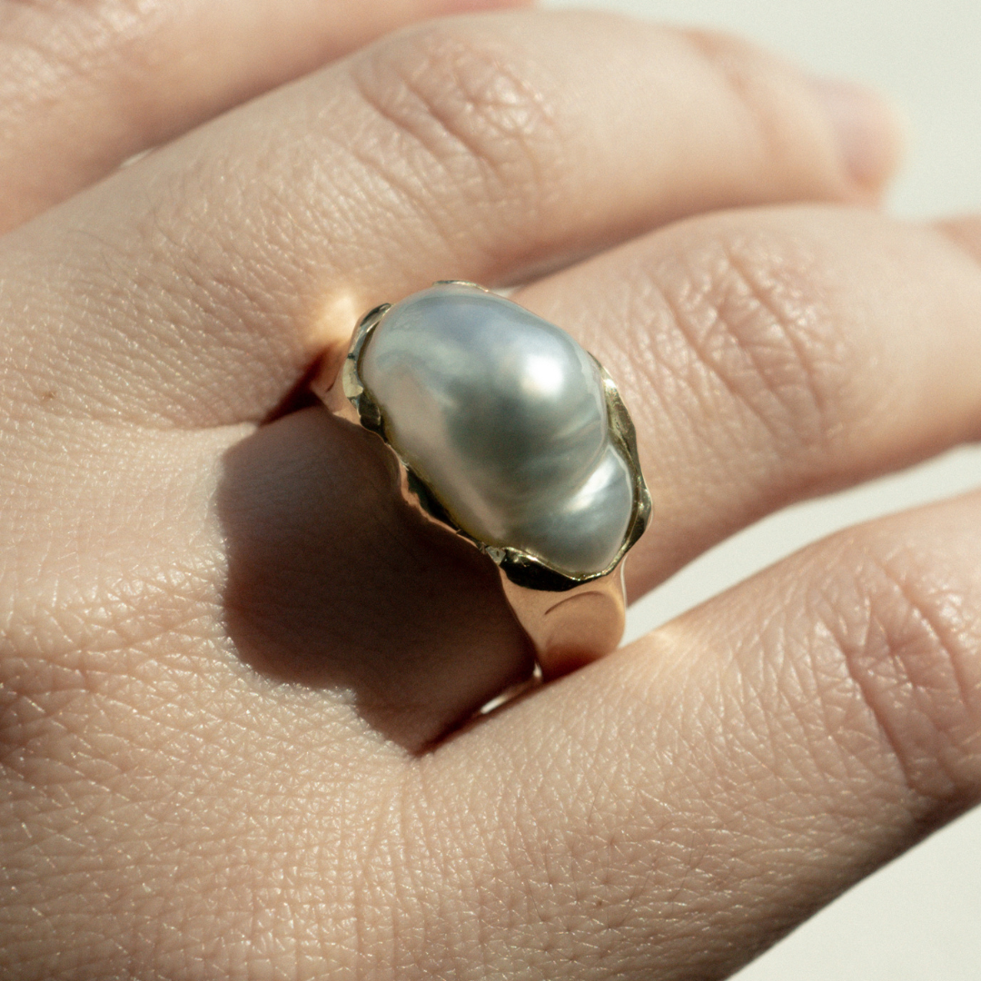 A person wears their Keepsake Pearl Ring featuring a Cygnet Bay (WA) grown Australian South Sea Keshi pearl set in a bespoke gold design.