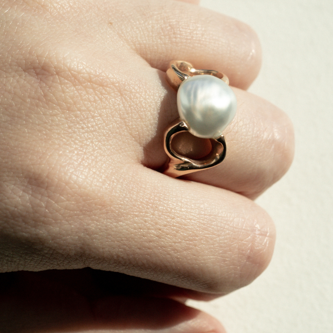 A person wears a stunning Keepsake Pearl Ring features a Cygnet Bay (WA) grown Australian South Sea Keshi pearl set in a bespoke gold design.