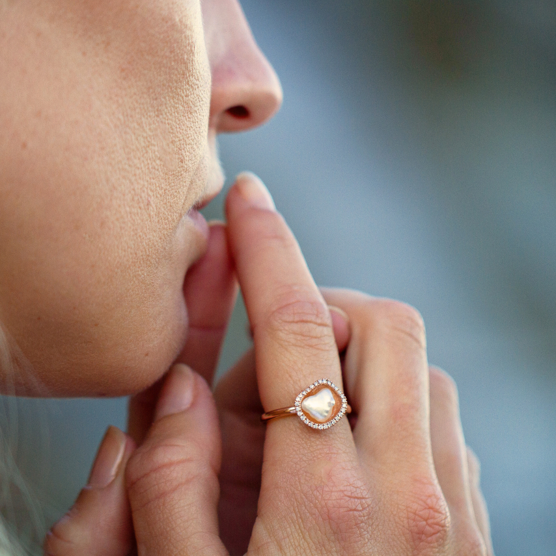 A woman wears her stunning Kimberley Lily Petite Diamond Pearl Ring featuring an Australian South Sea Keshi pearl set in gold with a halo of sparkling white diamonds.