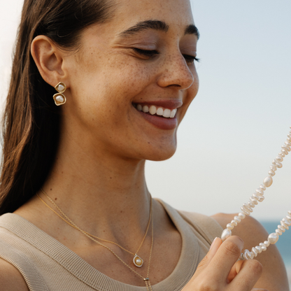 Woman wearing gold jewelry with a blurred background