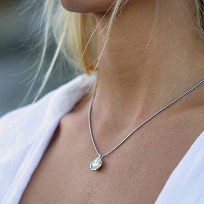 A woman wears her stunning Kimberley Lily Pearl Pendant featuring an Australian grown Australian Keshi pearl set in a unique lily inspired design.