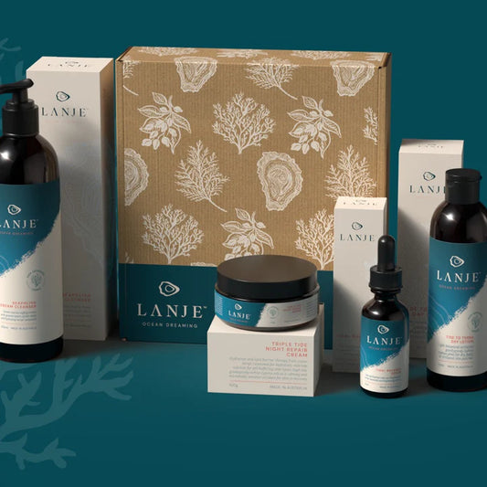 LANJE skincare products including bottles, jars, and boxes on a blue background with floral patterns.