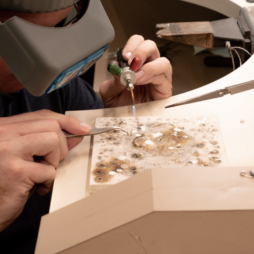 A jeweller works at his bench top, creating a beautiful pearl jewellery piece to be treasured for generations.