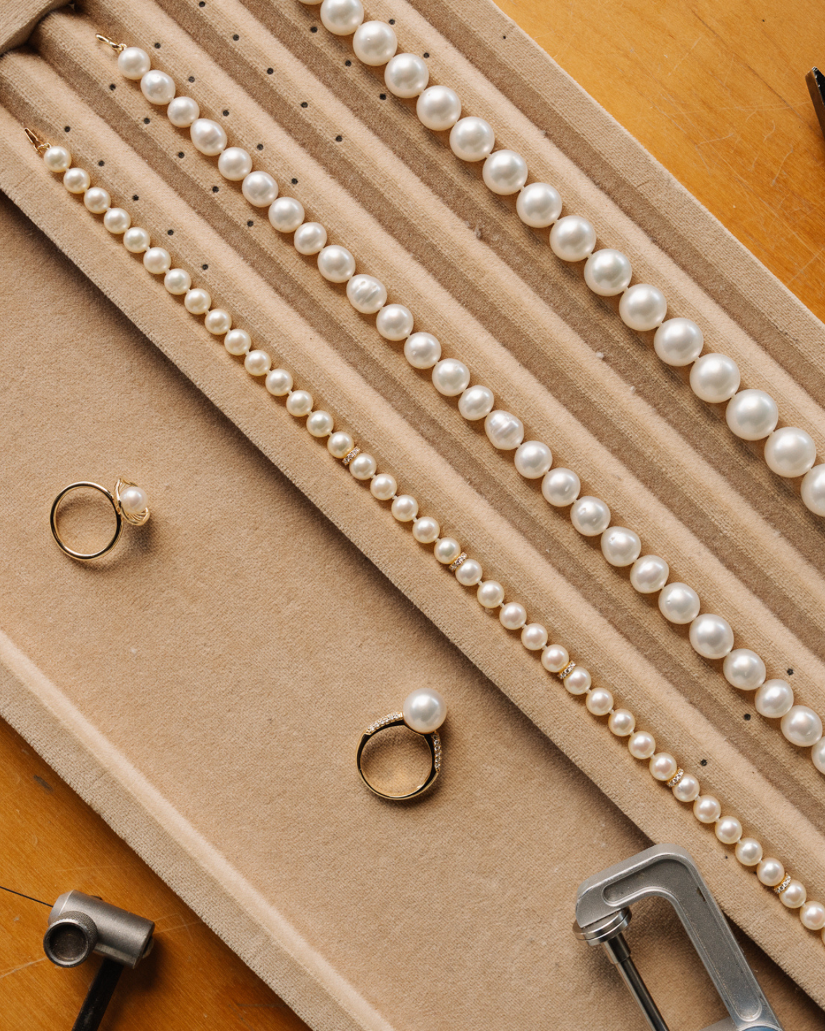 A tray of stunning Australian Saltwater pearl jewellery pieces, include pearl necklaces and rings, alongside calipers and other jewellery tools and implements. 