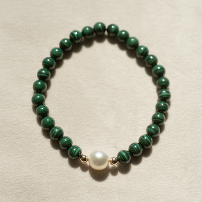 Featuring a luminous Cygnet Bay (WA) grown 8.5mm Near Round B1 grade Australian South Sea pearl nestled alongside 28 malachite beads and two 9ct yellow gold rondels