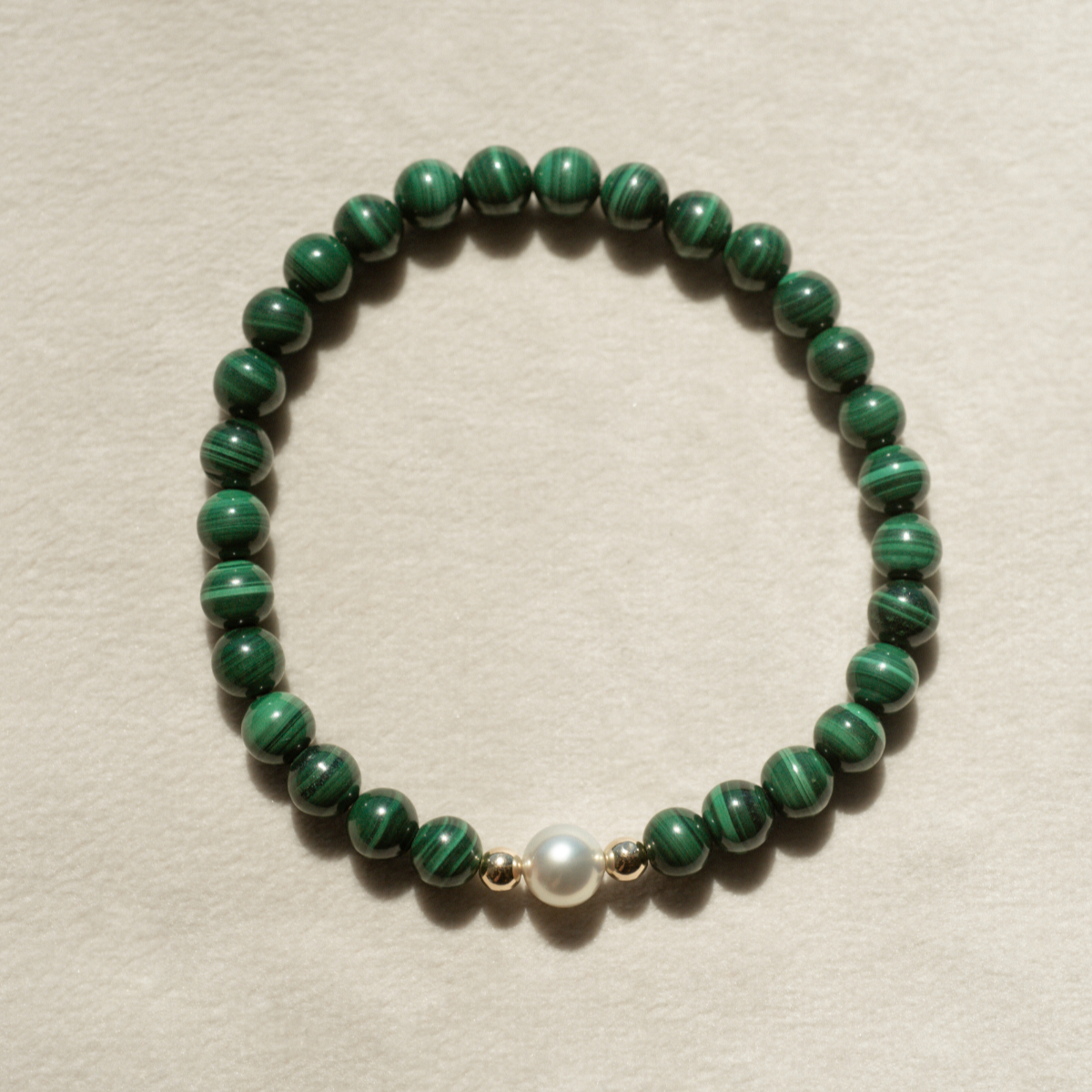 Featuring a luminous Broken Bay (WA) grown 7mm AAA grade Australian Akoya pearl nestled alongside 28 malachite beads and two 9ct yellow gold rondels