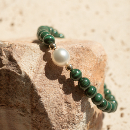 Featuring a luminous Cygnet Bay (WA) grown 8.5mm Near Round B1 grade Australian South Sea pearl nestled alongside 28 malachite beads and two 9ct yellow gold rondels