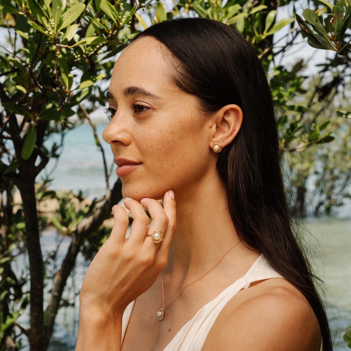 Woman with pearl jewellery standing under Mangrove Trees at our pearl farm.