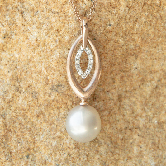 Pearl pendant necklace on a beige textured background