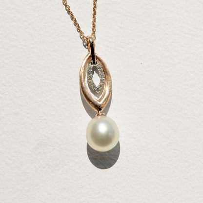 Pearl pendant on a chain against a light gray background