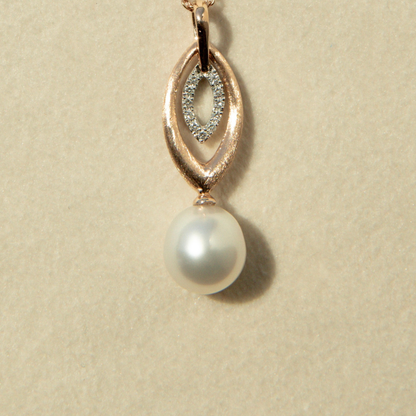 Pearl pendant with rose gold and diamond accents on a beige background