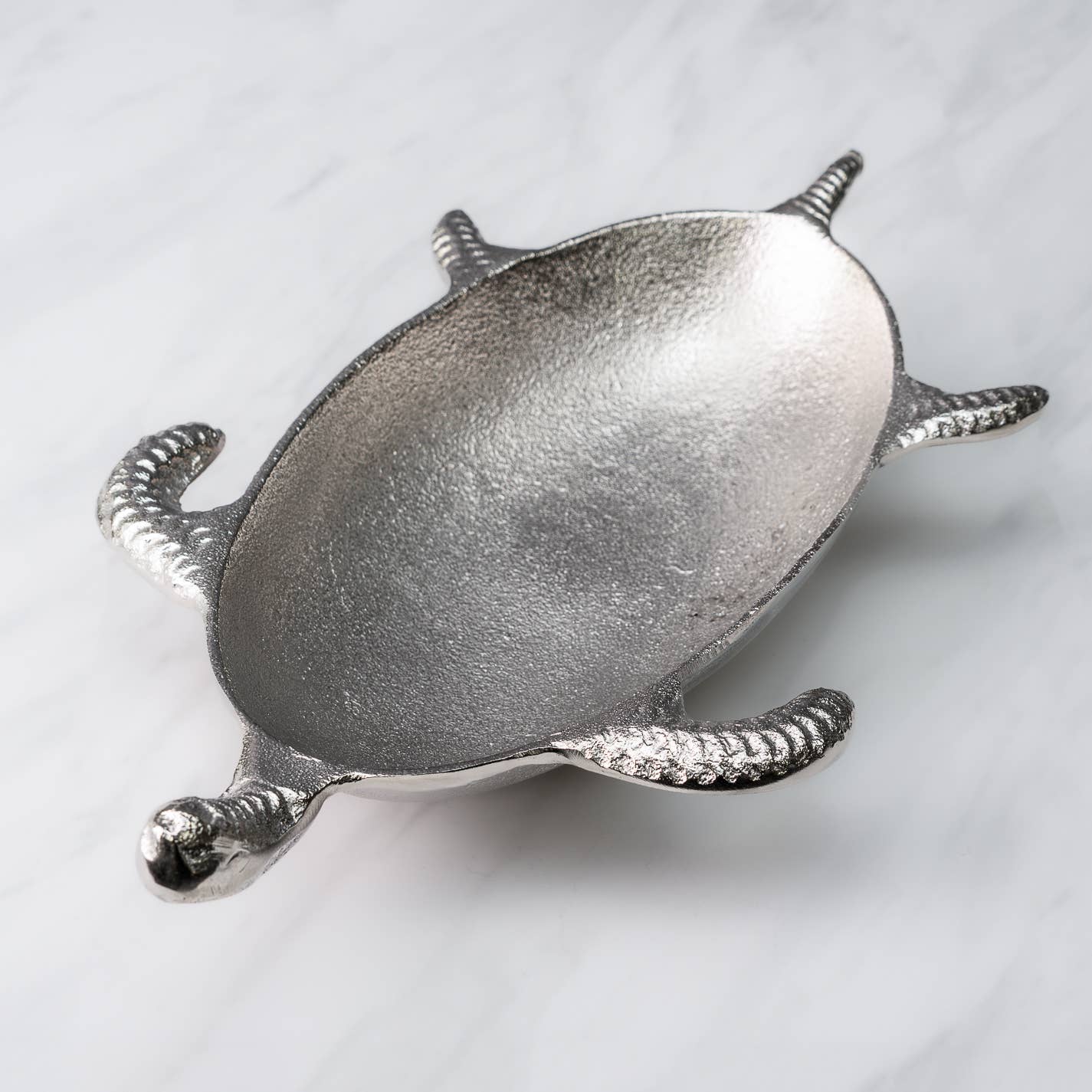 Silver turtle-shaped dish on a light gray background