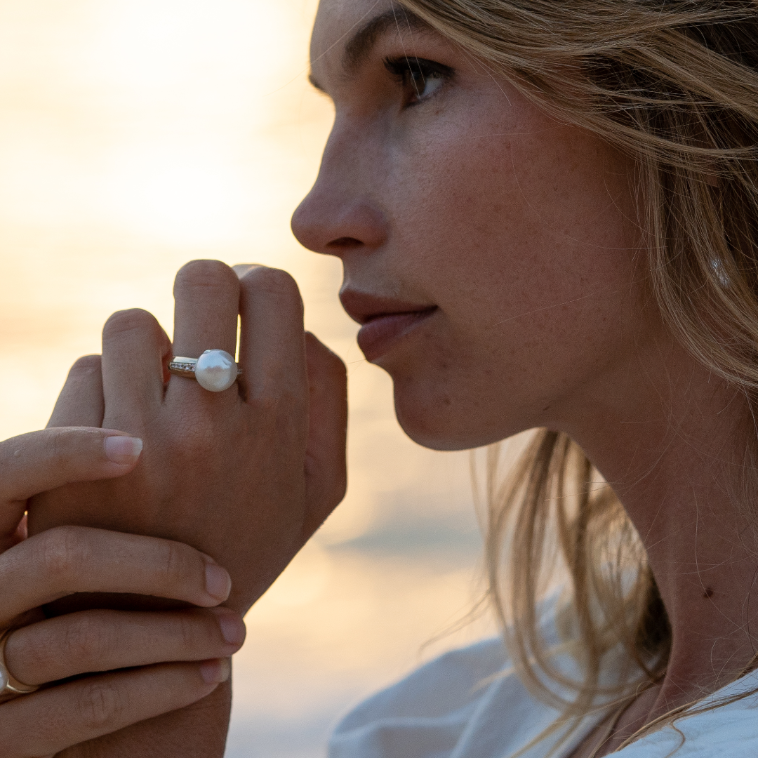 A woman wears her classic Mojo Diamond Pearl Ring featuring a Cygnet Bay (WA) grown Australian South Sea pearl set alongside a band of White Diamonds.