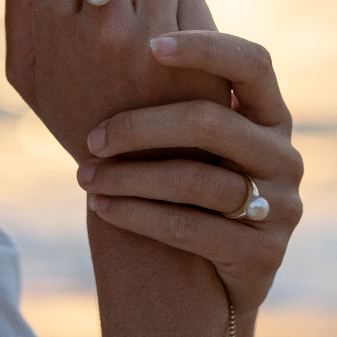 A  person wears their classic Mojo Pearl Ring features a Cygnet Bay (WA) grown Australian South Sea pearl set on a gold band.