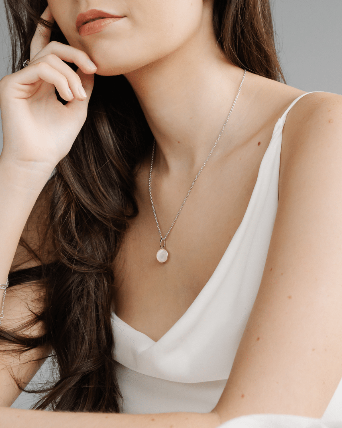 A woman wears her timeless My Planet Charm features our Cygnet Bay (WA) Australian South Sea Mother of Pearl shell set in Sterling Silver.