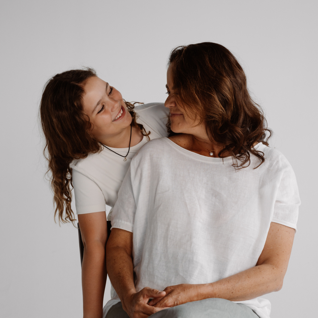 A mother and daughter wear their Mum and Me pearl charm set, where Mum wears her Australian South Sea pearl set on a gold chain and Daughter wears her Australian Akoya pearl set on a silk cord.